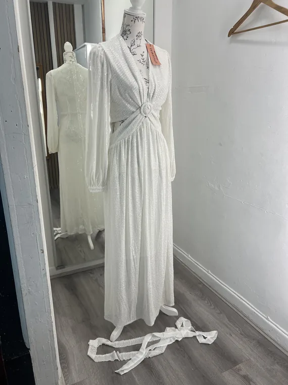 Two ivory gowns on mannequins in the fitting area